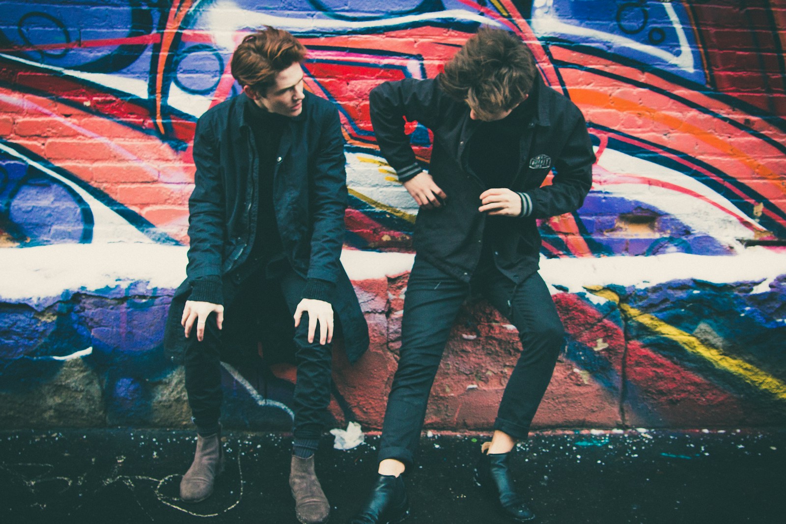 Discover the key differences between export clothing and local market clothing. Learn which option fits your style, budget, and needs with expert insights from Catfish., two men leaning against graffiti wall art